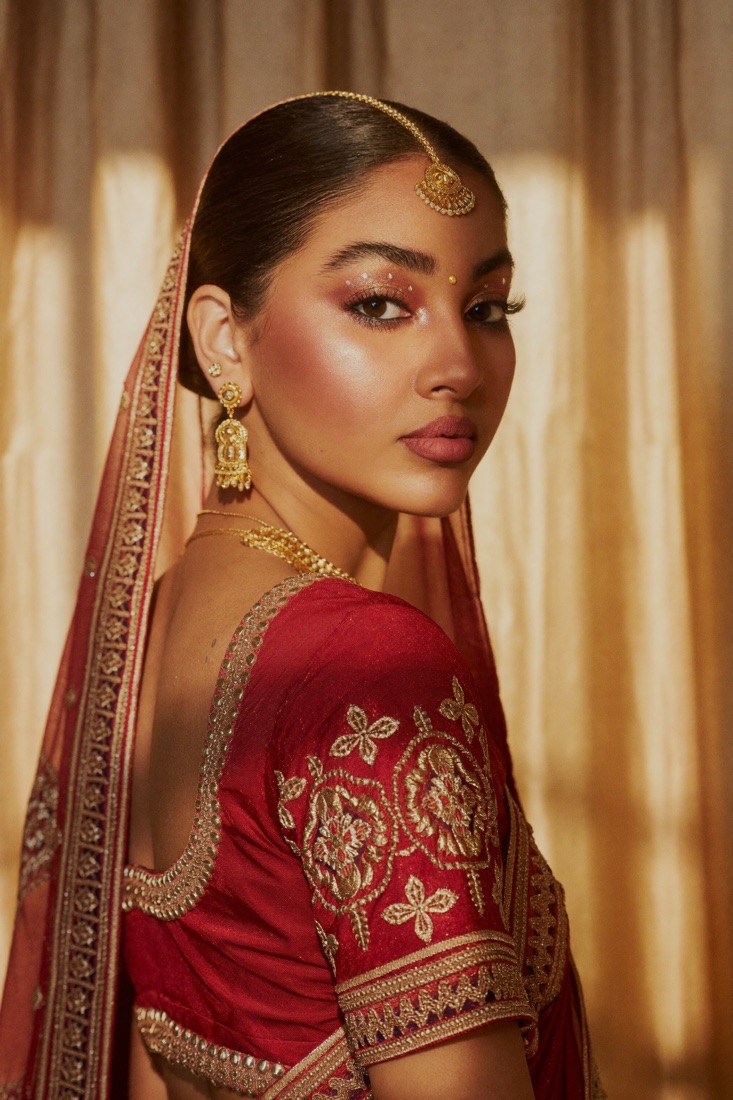 Bride in red and gold with soft glam makeup