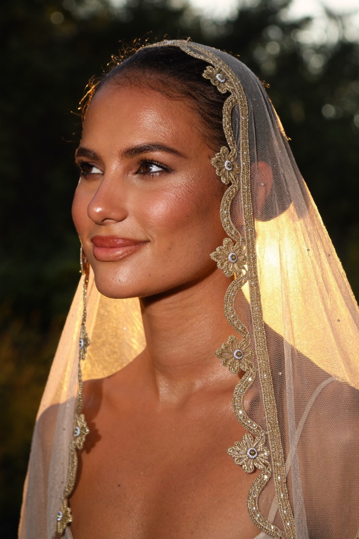 Bride in a veil at golden hour with glowing skin